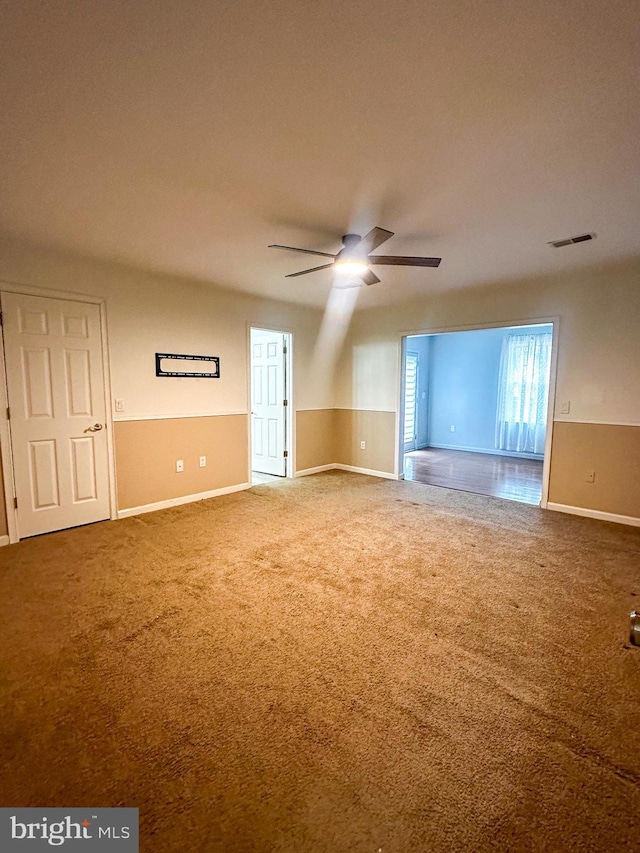 unfurnished room featuring ceiling fan and carpet flooring