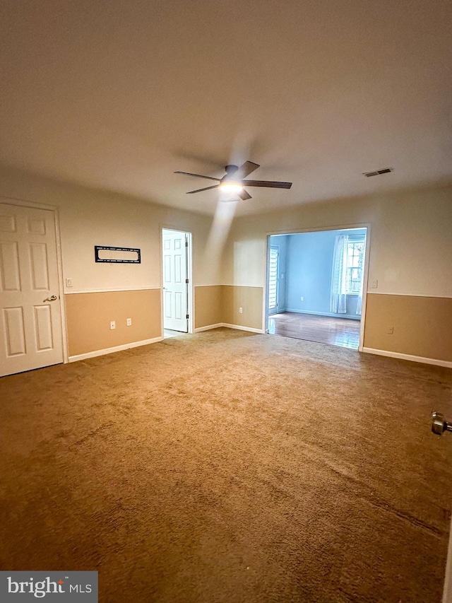 carpeted spare room featuring ceiling fan