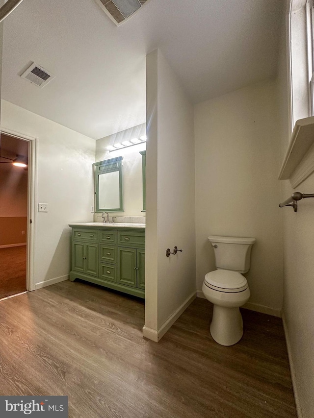 bathroom featuring toilet, hardwood / wood-style flooring, and vanity