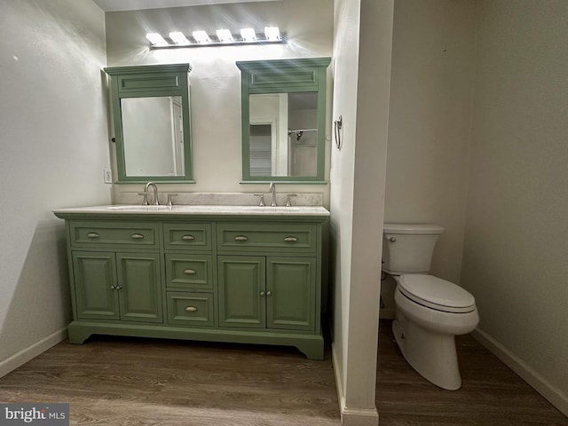 bathroom with hardwood / wood-style floors, toilet, and vanity