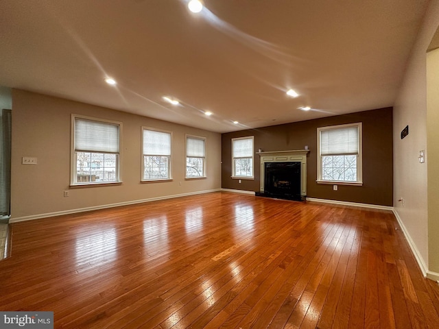 unfurnished living room with a healthy amount of sunlight and hardwood / wood-style flooring