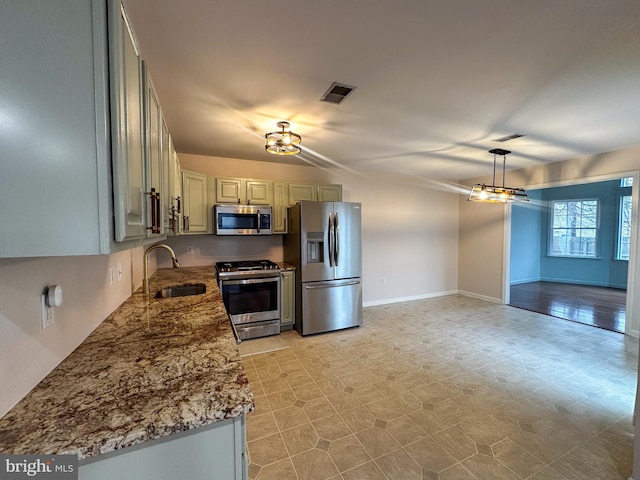 kitchen featuring light stone countertops, sink, and stainless steel appliances