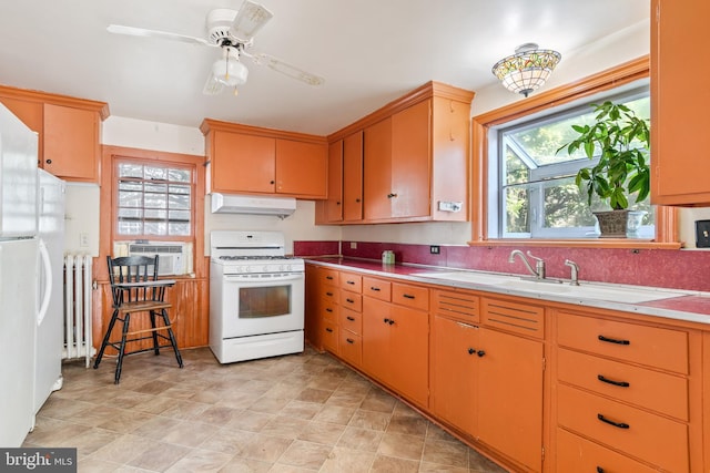 kitchen featuring radiator, white appliances, sink, ceiling fan, and cooling unit