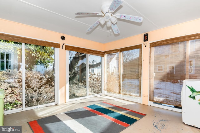 unfurnished sunroom with washer / dryer and ceiling fan