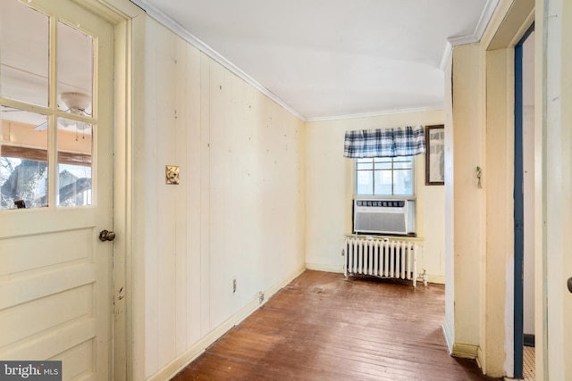 empty room featuring crown molding, dark wood-type flooring, radiator heating unit, and cooling unit