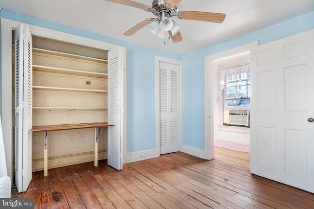 unfurnished bedroom featuring cooling unit, hardwood / wood-style flooring, and ceiling fan