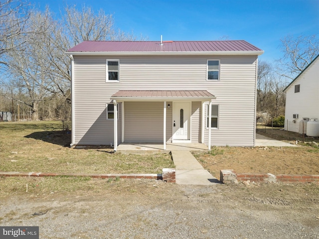 traditional home featuring metal roof, a porch, and a front yard