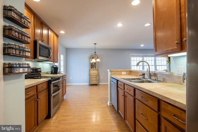 kitchen with stainless steel appliances, hanging light fixtures, sink, and plenty of natural light