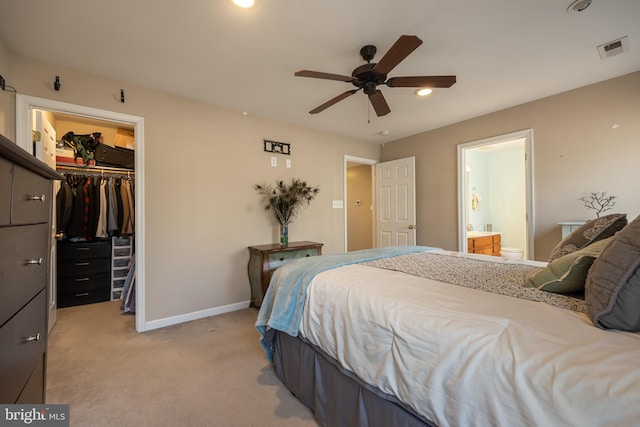 bedroom with carpet floors, a spacious closet, ceiling fan, ensuite bath, and a closet