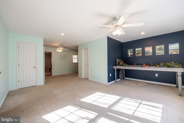 unfurnished living room featuring ceiling fan and light carpet