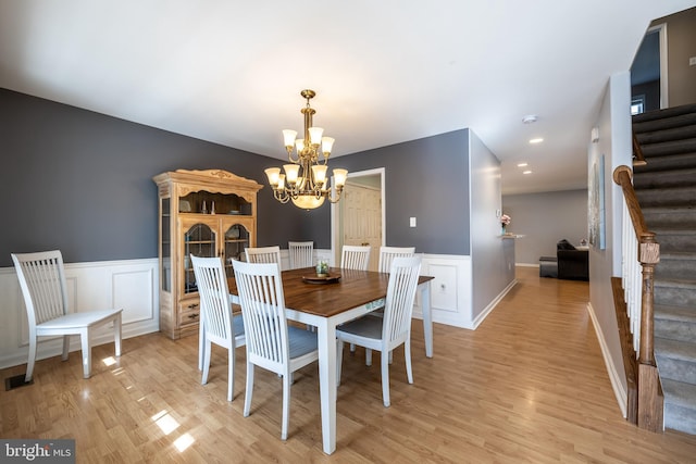 dining area featuring light hardwood / wood-style flooring and a notable chandelier