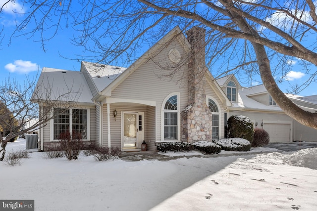 cape cod house featuring a garage and central AC