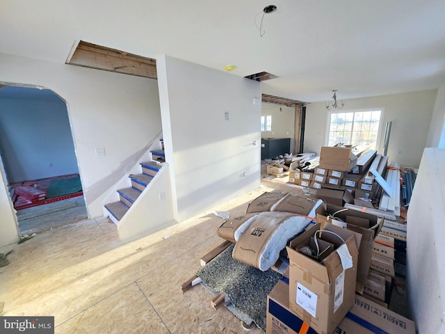 living room featuring arched walkways, stairs, a notable chandelier, and visible vents