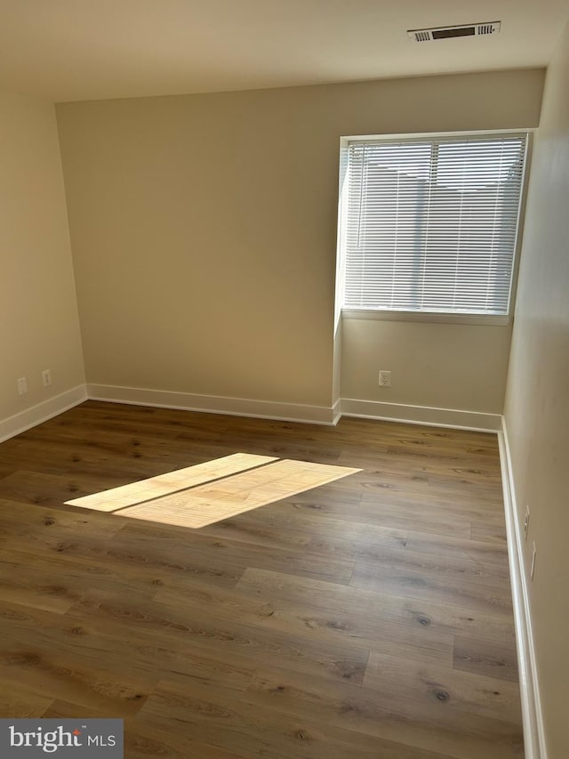 unfurnished room with hardwood / wood-style flooring