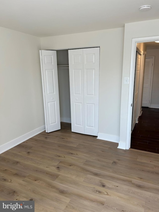 unfurnished bedroom with a closet and hardwood / wood-style floors