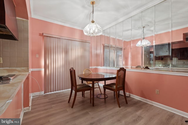 dining room with light wood-type flooring, a notable chandelier, and crown molding