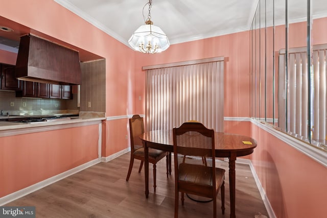 dining room featuring crown molding, a notable chandelier, and light wood-type flooring