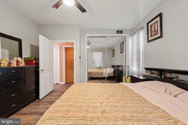 bedroom featuring light wood-type flooring, ceiling fan, and a closet