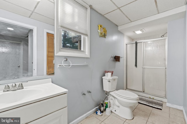 bathroom with toilet, vanity, tile patterned flooring, walk in shower, and a paneled ceiling