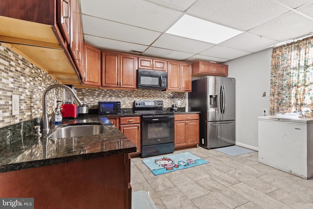 kitchen with black appliances, dark stone counters, tasteful backsplash, sink, and a drop ceiling