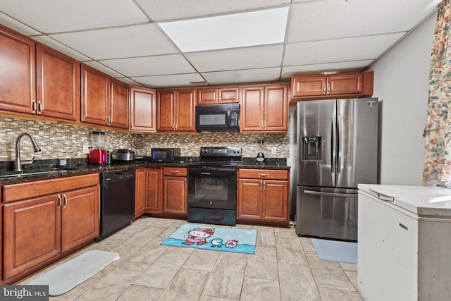 kitchen featuring a paneled ceiling, sink, backsplash, and black appliances