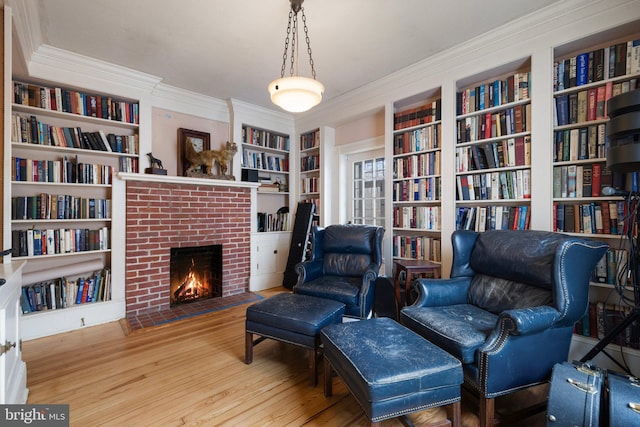 sitting room featuring hardwood / wood-style floors, a fireplace, and ornamental molding