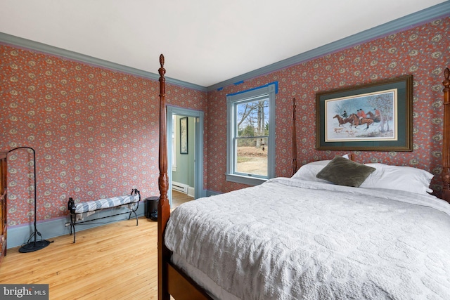 bedroom featuring ornamental molding, wood-type flooring, and a baseboard radiator