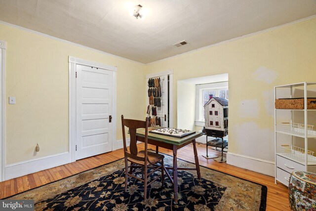 office space featuring crown molding and light hardwood / wood-style floors