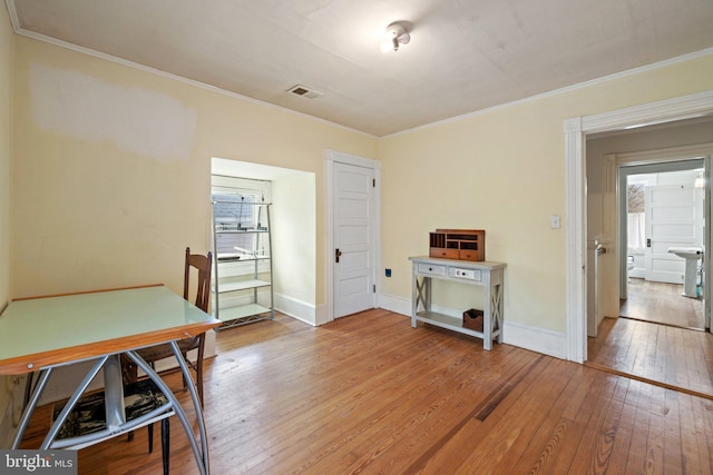 office featuring wood-type flooring, plenty of natural light, and crown molding