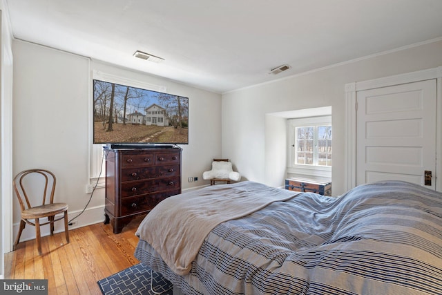 bedroom featuring crown molding and light hardwood / wood-style floors