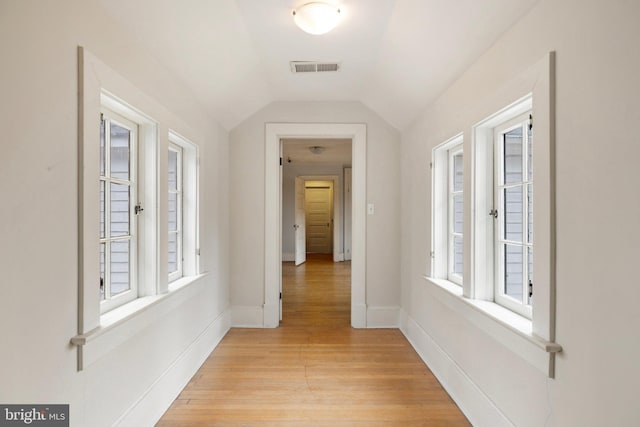 hallway featuring vaulted ceiling and light wood-type flooring