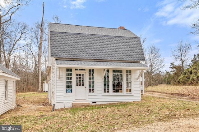 back of property with an outdoor structure and a yard