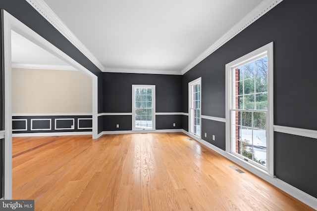 spare room featuring hardwood / wood-style flooring and ornamental molding