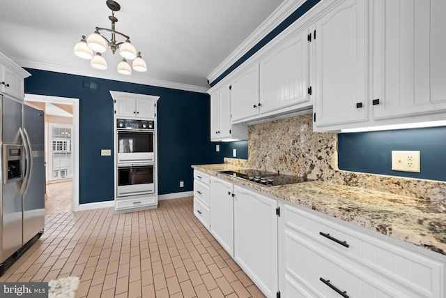 kitchen with stainless steel fridge with ice dispenser, hanging light fixtures, decorative backsplash, black electric cooktop, and an inviting chandelier