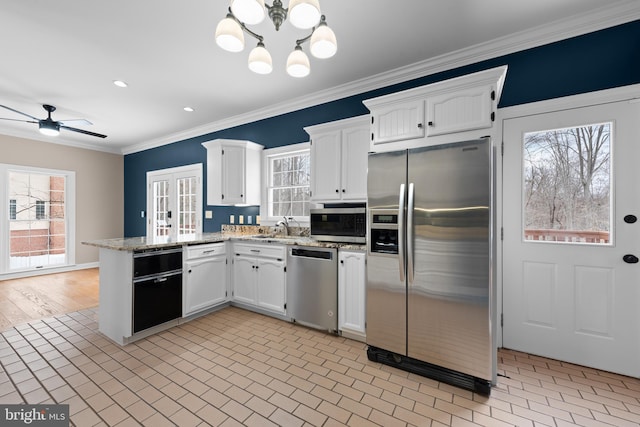 kitchen featuring ceiling fan with notable chandelier, appliances with stainless steel finishes, white cabinetry, light stone counters, and crown molding