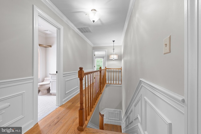 staircase with hardwood / wood-style flooring and crown molding