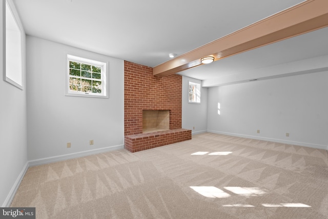 unfurnished living room with a fireplace, light colored carpet, and beamed ceiling