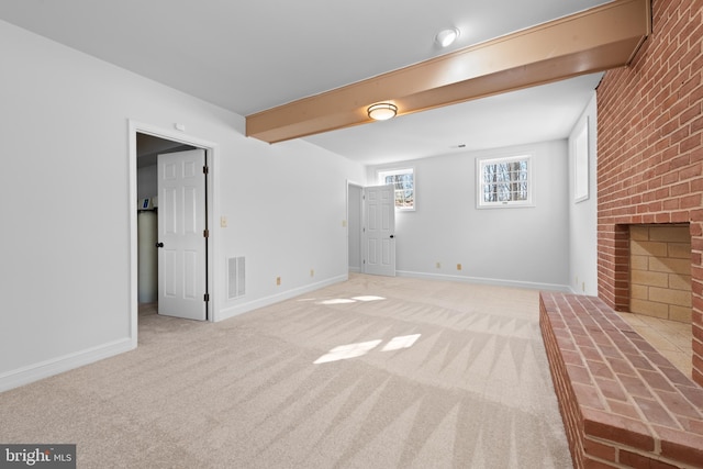 unfurnished living room featuring light colored carpet, beamed ceiling, and a fireplace