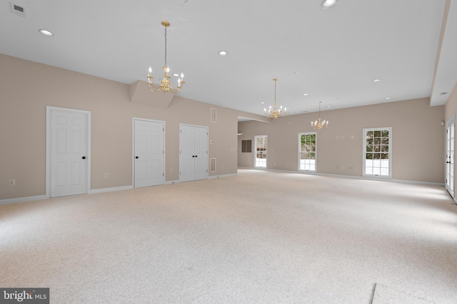 unfurnished living room with a chandelier and carpet