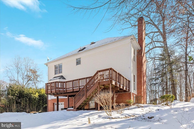 snow covered rear of property featuring a deck