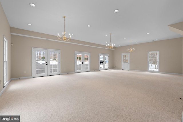 spare room featuring light colored carpet and french doors