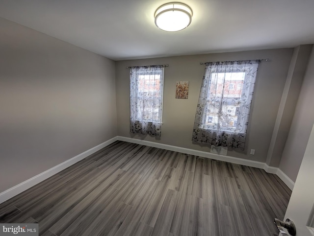 spare room with a healthy amount of sunlight and hardwood / wood-style flooring