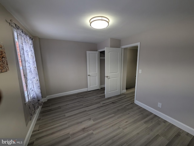 unfurnished bedroom with dark hardwood / wood-style flooring