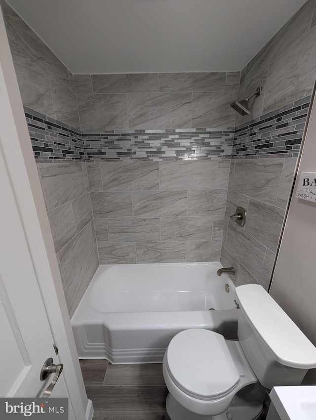 full bathroom featuring toilet, tiled shower / bath, vanity, and hardwood / wood-style floors