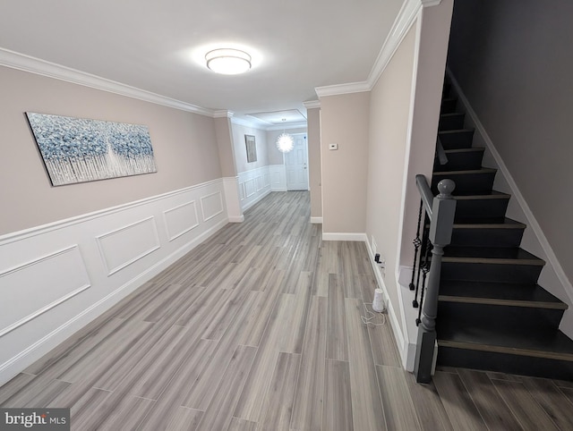 corridor featuring light wood-type flooring and crown molding