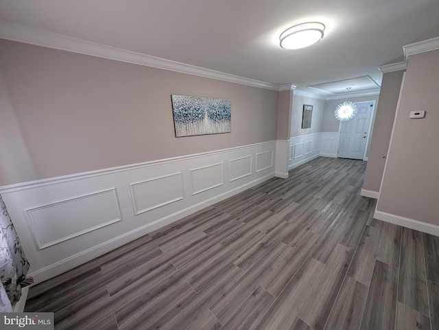 empty room featuring a chandelier, crown molding, and dark hardwood / wood-style floors