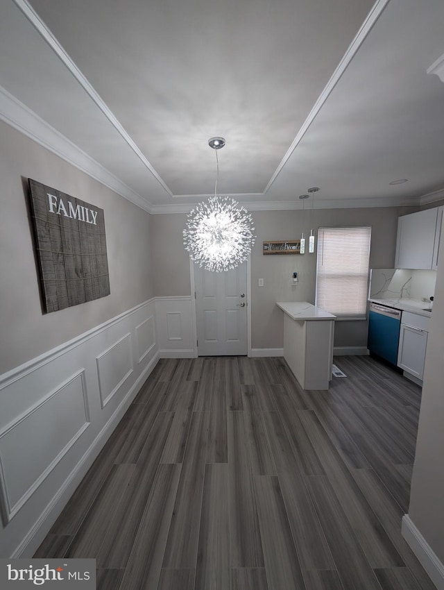 unfurnished dining area with dark hardwood / wood-style flooring, crown molding, and a notable chandelier