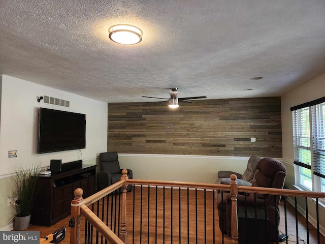 interior space featuring a textured ceiling and wood walls