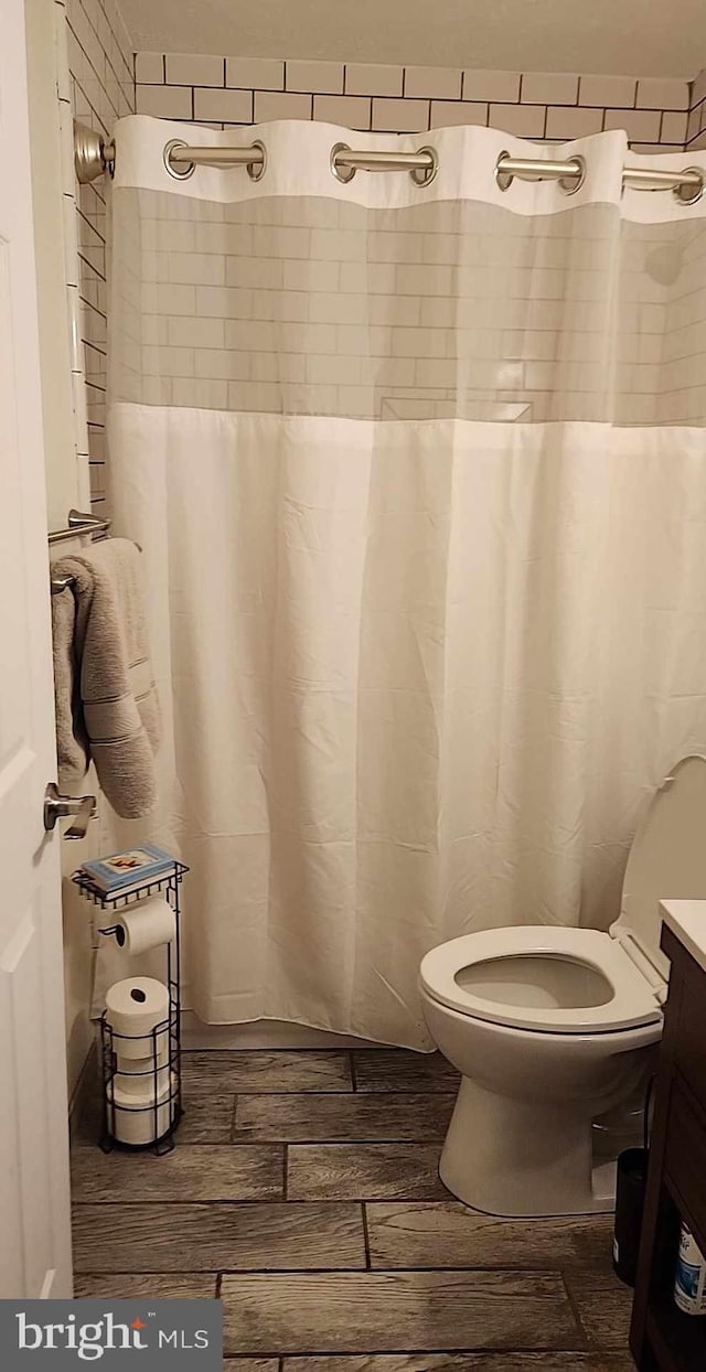 bathroom featuring vanity, hardwood / wood-style floors, and toilet