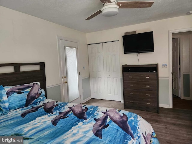 bedroom with ceiling fan, a textured ceiling, dark hardwood / wood-style flooring, and a closet